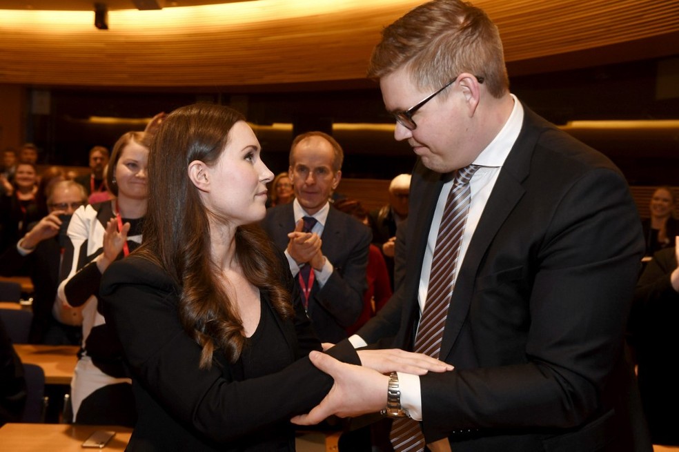 Sanna Marin recebe os cumprimentos do candidato que ela derrotou,  Antti Lindtman, em 8 de dezembro de 2019 — Foto: Vesa Moilanen / Lehtikuva / AFP