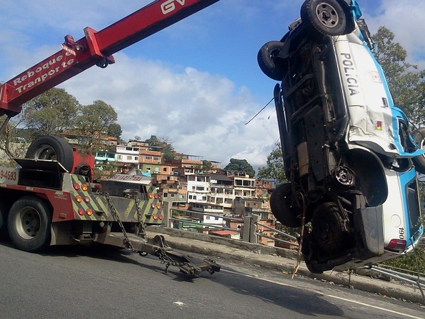 Carro da PM é retirado da Autoestrada Grajaú-Jacarepaguá. (Foto: Lilian Quaino/G1)