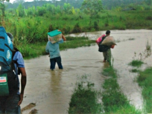 Moradores caminham em estrada alagada (Foto: Maria da Conceição/Arquivo Pessoal)