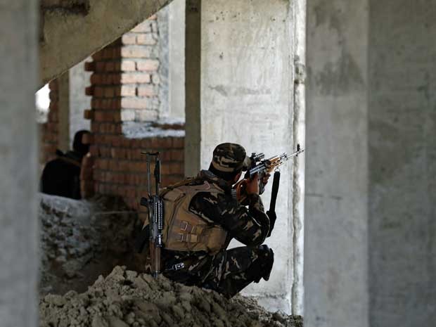 Homem das forças de segurança do Afeganistão toma posição durante confronto com insurgentes em Cabul. (Foto: Mohammad Ismail / Reuters)