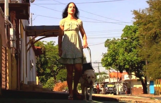 Coordenadora da Associação de Deficientes Visuais em Goiás Wactusa Oliveira e o cão-guia Polo (Foto: Reprodução/TV Anhanguera)