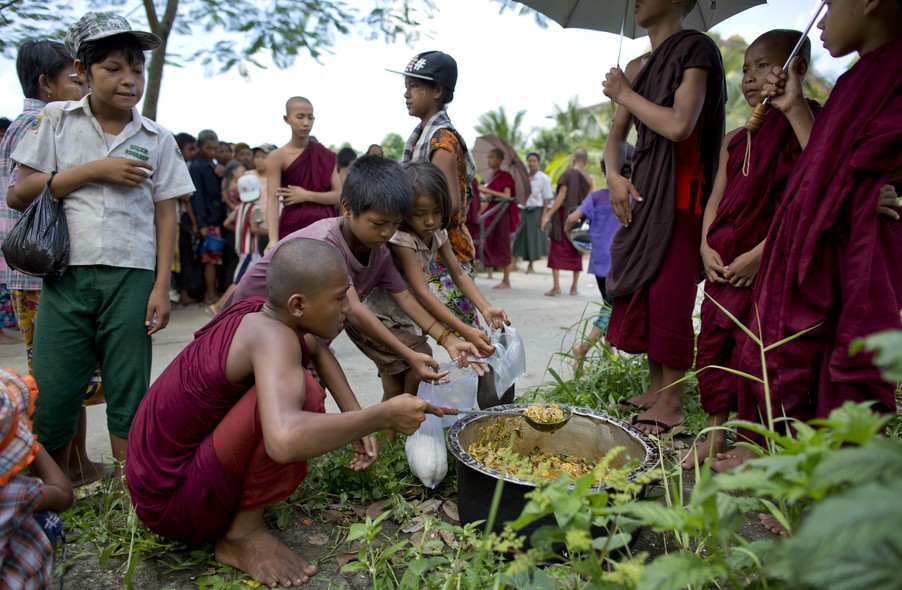 Crianças de rua recebem almoço de monges budistas, em Hlaing Thaya,em Myanmar. Todos os dias eles distribuem café da manhã e almoço feito com as doações que recebem de fieis