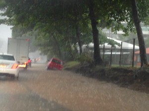 Um carro caiu num buraco e ficou enguiçado durante a chuva forte na Estrada Lagoa-Barra, em São Conrado, na Zona Sul (Foto: Perla Rodrigues/ G1)