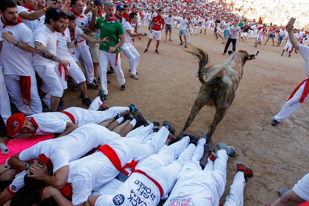 Touro pula sobre grupo de homens durante Festival de São Firmino, em Pamplona, na Espanha  (Foto: Alvaro Barrientos/ AP)