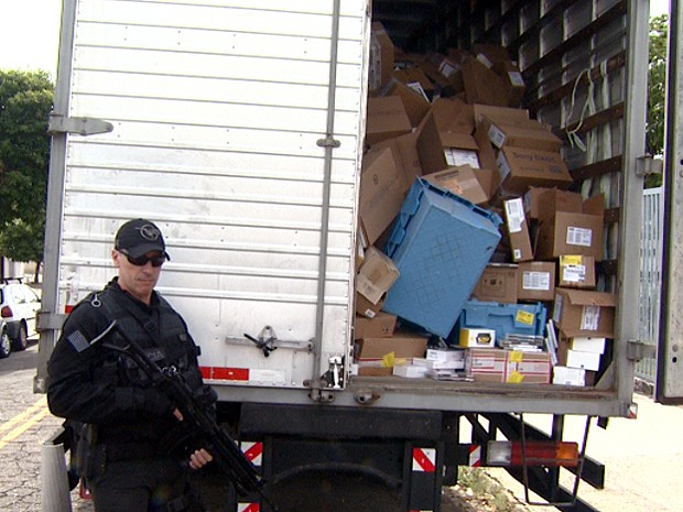 Policial Civil ao lado do caminhão com carga roubada do Magazine Luiza (Foto: Márcio Silveira/EPTV)