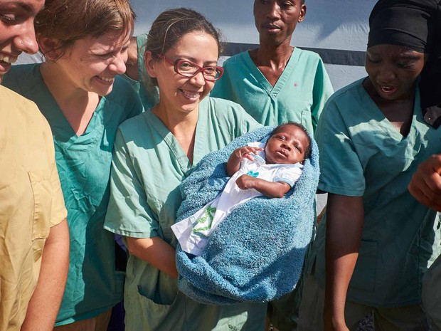 A bebê quando nasceu no colo de Nubia Aguiar, enfermeira brasileira que ajudou a atendê-la na Guiné (Foto: Sam Phelps/Médicos sem Fronteiras)