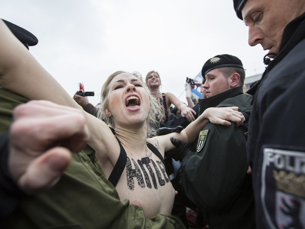 Uma ativista do Femen é detida pela polícia durante uma manifestação contra um comício do partido de extrema direita alemão em Berlim. (Foto: Florian Schuh/AFP)