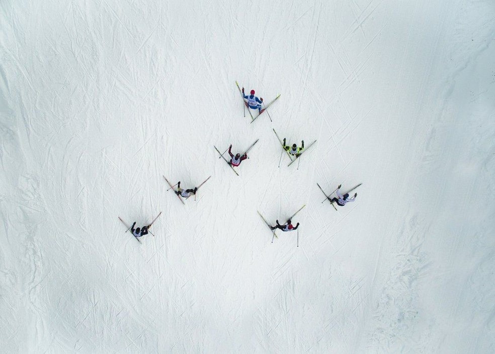 Um grupo de esquiadores desliza quase em forma geométrica sobre a neve na montanha de Adzhigardak, na Rússia. (Foto: Maksim Tarasov)