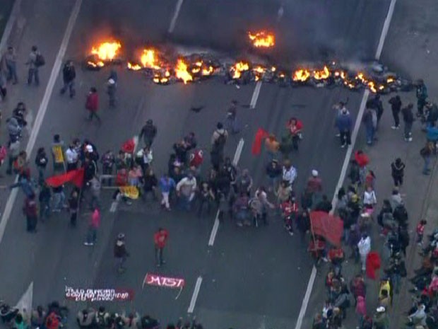Manifestantes usam pneus e madeira incendiados para fechar pista (Foto: Reprodução/TV Globo)