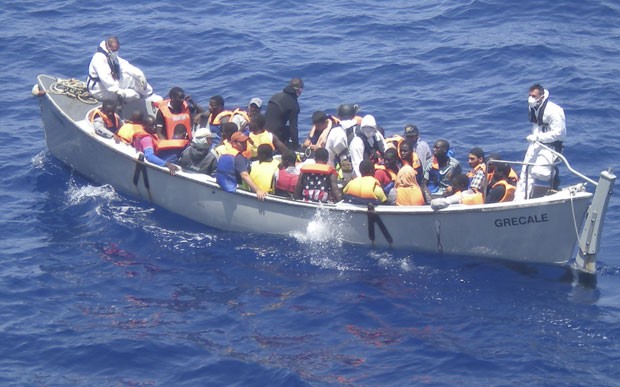 Imigrantes são resgatados de barco que levava cerca de 600 pessoas na costa da Itália. Cerca de 30 morreram asfixiados (Foto: Marinha da Itália/AP)