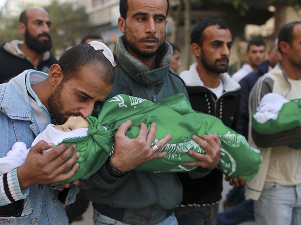 18 de novembro - Palestino beija corpo do filho morto durante funeral na Gaixa de Gaza. Dois irmãos, de 18 meses e 3 anos, morreram em um ataque aéreo   (Foto: Mohammed Salem/Reuters)