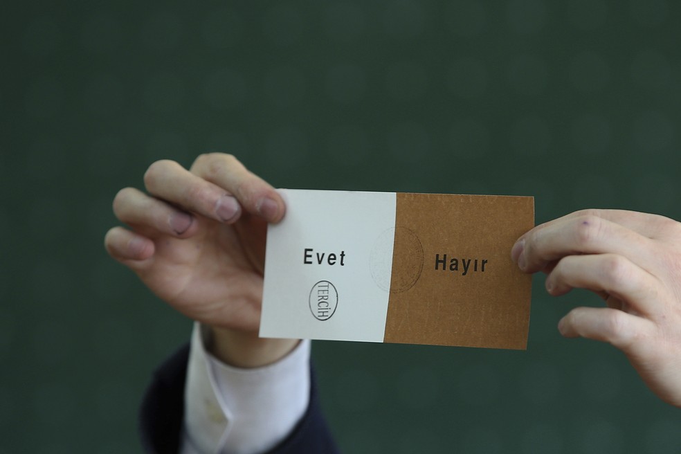Membro de comitê eleitoral exibe cédula usada no referendo deste domingo (16) na Turquia, com carimbo na opção 'Sim' (Foto: AP Photo/Emrah Gurel)