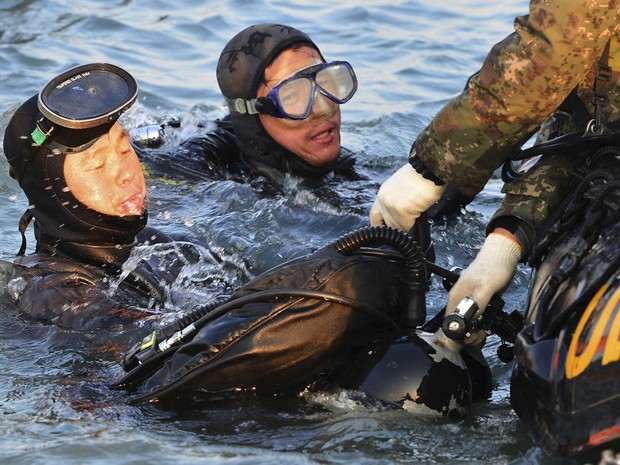Mergulhadores retiram corpo de vítima do naufrágio de balsa  (Foto: Yonhap/AP)