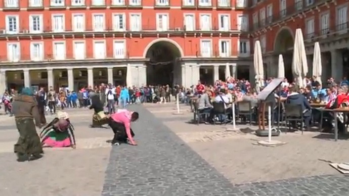 Mendigas pegam no chÃƒÂ£o moedas jogadas por torcedores do PSV em Madri (Foto: ReproduÃƒÂ§ÃƒÂ£o de vÃƒÂ­deo)