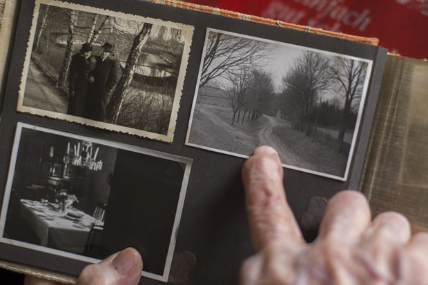 Margot Woel mostra um velho álbum de fotos e aponta para uma foto tirada do caminho para a 'Toca do Lobo' (Foto: Markus Schreiber/AP)