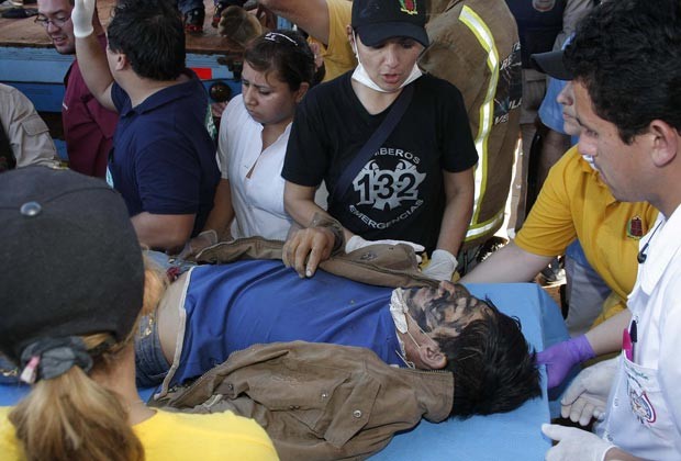 Sem-terra ferido é socorrido nesta sexta-feira (15) no Paraguai (Foto: AP)