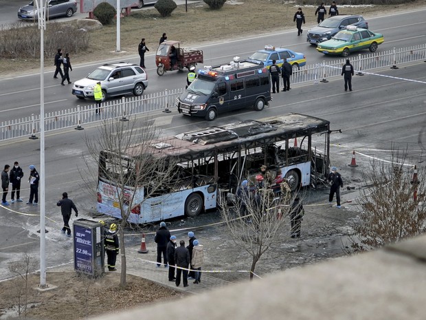 Bombeiros e policiais fazem o trabalho de rescaldo após o ônibus pegar fogo na China (Foto: Stringer/Reuters)