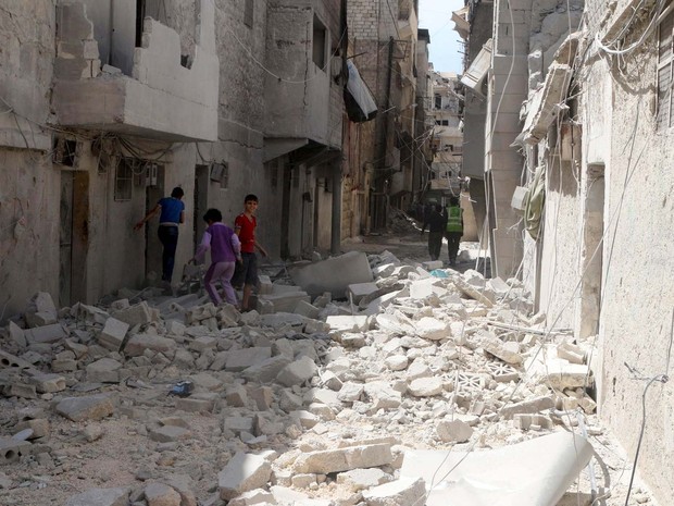 Moradores nesta segunda-feira (11) observam danos após ataque aéreo a bairro de Aleppo controlado por rebeldes (Foto: REUTERS/Abdalrhman Ismail)
