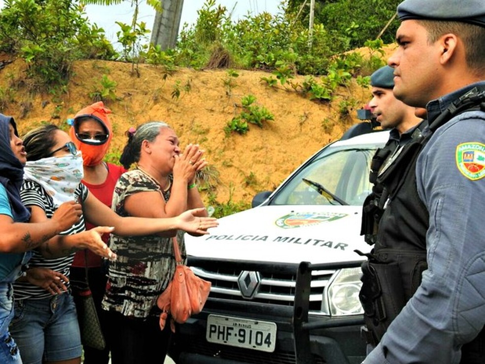 Familiares de presos cobrem rostos e pedem informações de policiais sobre mortes em presídio em ManausManaus ( (Foto: Isis Capistrano / G1 AM)