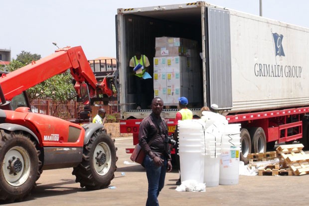 Integrantes do Médicos Sem Fronteiras descarregam equipamentos médicos para tratar epidemia de ebola na guiné neste domingo (23) (Fot Saliou Samb/Reuters)