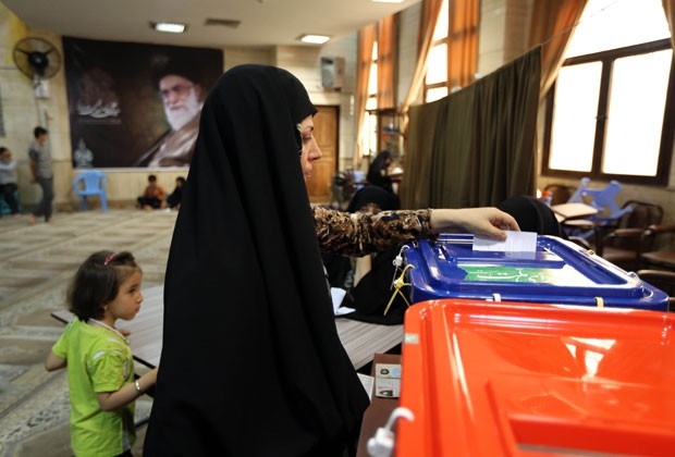Mulher iraniana vota ao lado de sua filha em zona eleitoral em Teerã (Foto: Atta Kenare/AFP)