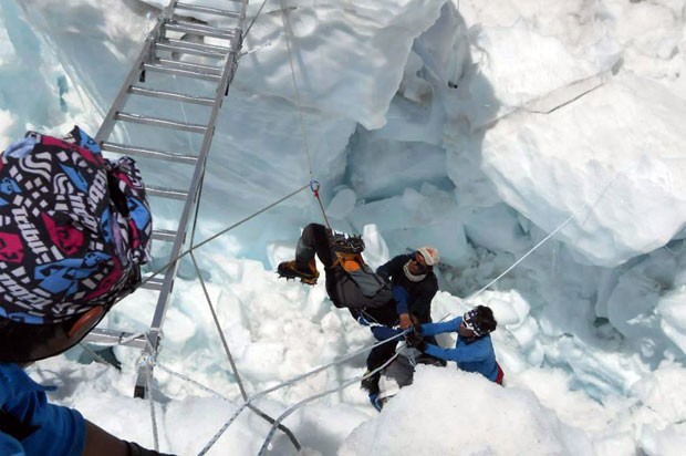 Equipes resgatam um sobrevivente da avalanche que matou 12 pessoas no Monte Everest nesta sexta-feira (18). Quatro guias ainda estão desaparecidos (Foto: AFP)