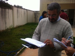 Pastor Samuel da Silva Soares confere a lista com os nomes dos passageiros dos ônibus. (Foto: Diego Souza/G1)