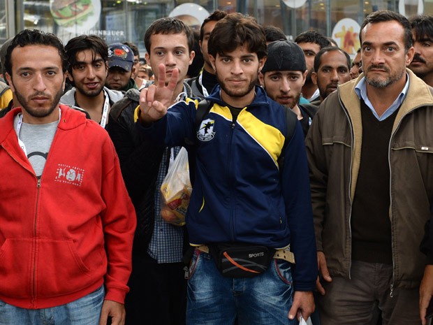 Refugiados esperam por um trem especial na principal estação ferroviária de Munique, neste domingo (13) (Foto: AFP PHOTO/CHRISTOF STACHE)