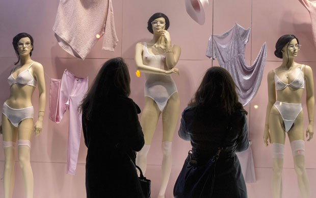 Pedestres observam manequins decorados com cabelo e pelos pubianos na loja da American Apparel (Foto: Brendan McDermit/Reuters)