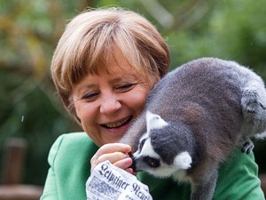 A chanceler da Alemanha, Angela Merkel, alimentou um lêmure durante uma visita a um parque de animais em Marlow, no nordeste do país, nesta quinta-feira (30) (Foto: Jens Buettner/dpa via AP)