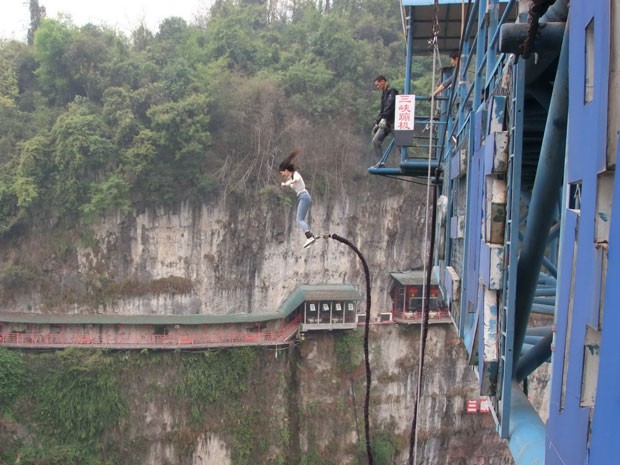 Mulher pula de bungee jump de plataforma próxima ao restaurante Fangweng , no Vale Feliz, na China (Foto: Han Yuhong / Imaginechina/ AFP)