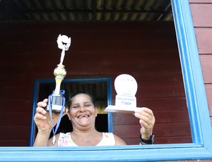 Maria exibe os troféus e medalhas garantidos com o bicampeonato (Foto: Larissa Vieira/GLOBOESPORTE.COM)