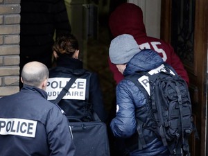 Um homem preso é escoltado pela polícia em um hotel em Montrouge, subúrbio no sul de Paris, durante as investigações do atentado à revista francesa 'Charlie Hebdo'. Doze pessoas foram mortas após dois atiradores invadirem a sede da publicação (Foto: Kenzo Tribouillard/AFP)