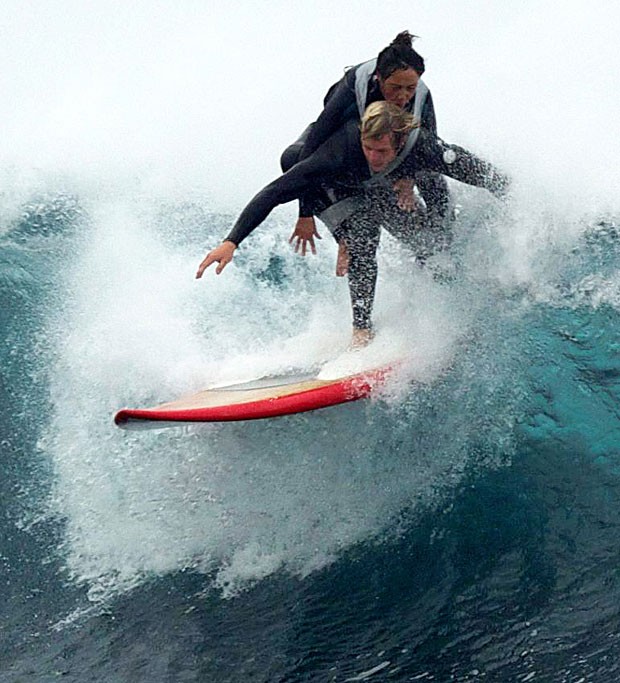 Recorte na imagem mostra as posições que os dois adotam para que os movimentos do surfista não sejam atrapalhados pela 'carona' (Foto: SWNS/The Grosby Group)