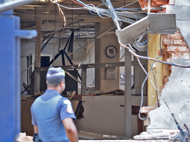 Policial militar observa a parte interior da empresa que ficou completamente destruída (Foto: Felipe Albertoni/G1)