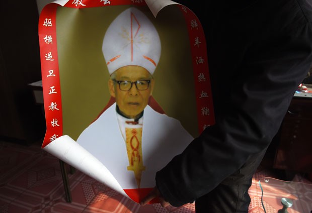 Parente do bispo católico Shi Enxiang mostra foto do religioso nesta terça-feira (24) em Shizhuang, na China (Foto: Greg Baker/AFP)