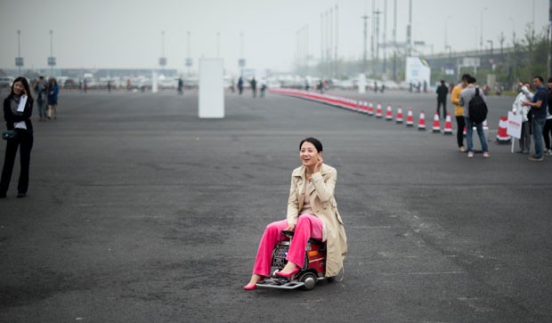 Mulher exibiu minicarro durante feira automobilística em Xangai (Foto: Johannes Eisele/AFP)