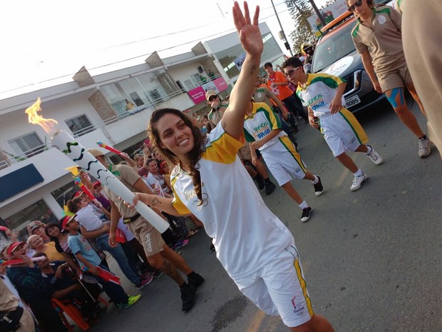 A goleira da seleção brasileira de futsal, Missiara Luiza Papst, carrega a tocha olímpica em Ilhota nesta terça-feira (12) (Foto: Marcelo Siqueira / RBSTV)