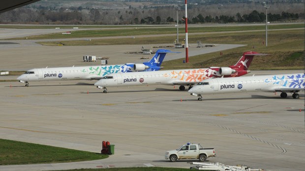 Aviões da Pluna no aeroporto de Montevidéu, no Uruguai. A empresa deixou de operar no Brasil na quinta-feira (5), e a Anac afirmou que está fiscalizando a prestação de assistência aos passageiros a companhia. (Foto: Miguel Rojo/AFP)