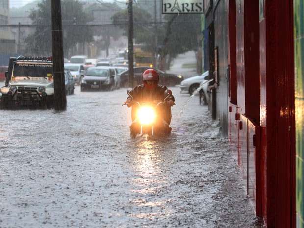 Motoqueiro passa por rua alagada em Curitiba, no Paraná. Segundo o Sistema Meteorológico do Paraná a cidade registrou um volume de chuva de 28 milímetros (Foto: Franklin de Freitas/Estadão Contéudo)