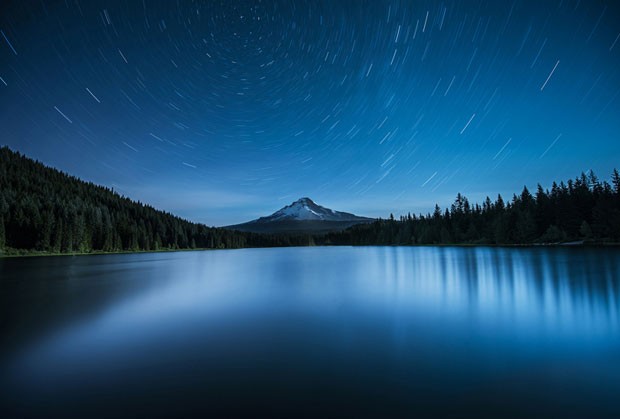 A Estrela do Norte, Polaris, aparece alinhada com o Mount Hood, no Oregon (EUA), e o lago Trillium. O fotógrafo usou exposição de 20 minutos para criar rastros de estrelas mapeando a rotação da Terra (Foto: Garrett Suhrie/Observatório Real de Greewich) A Estrela do Norte, Polaris, aparece alinhada com o Mount Hood, no Oregon (EUA), e o lago Trillium. O fotógrafo usou exposição de 20 minutos para criar rastros de estrelas mapeando a rotação da Terra (Foto: Garrett Suhrie/Observatório Real de Greewich)