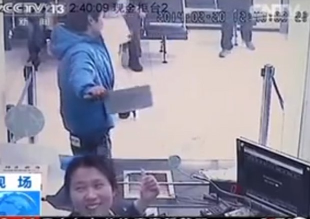 Do outro lado do vidro de segurana, funcionria 'tirou sarro' de ladro que tentou roubar banco com cutelo em Xangai, na China (Foto: Reproduo/YouTube/nexttv1000)