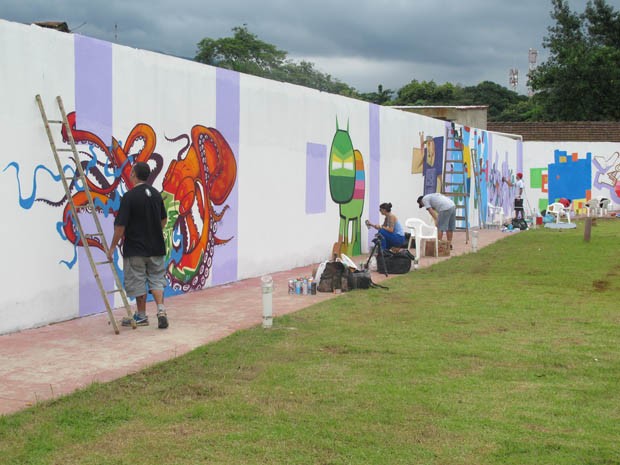 Desenhos sendo feitos no muro do Parque Anilinas, em Cubatão, SP (Foto: Mariane Rossi/G1)