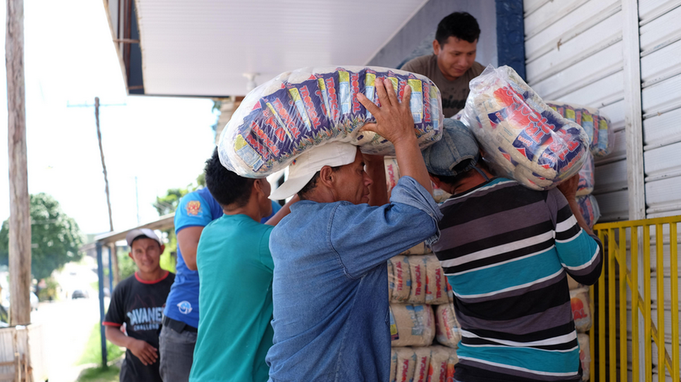 Exportação de arroz despontou entre janeiro e julho deste ano; Na foto, trabalhadores de Pacaraima, cidade na fronteira com a Venezuela, carregam fardos de arroz para estabelecimento (Foto: Inaê Brandão/G1 RR/Arquivo )