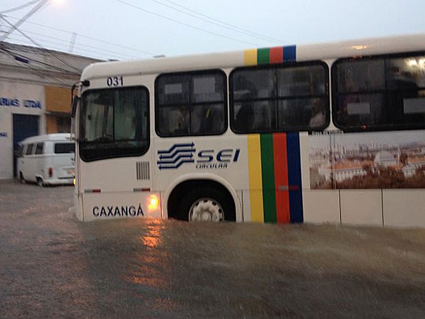 Água alcança quase todo o pneu de ônibus, no Centro do Recife (Foto: Marjones Pinheiro / TV Globo)