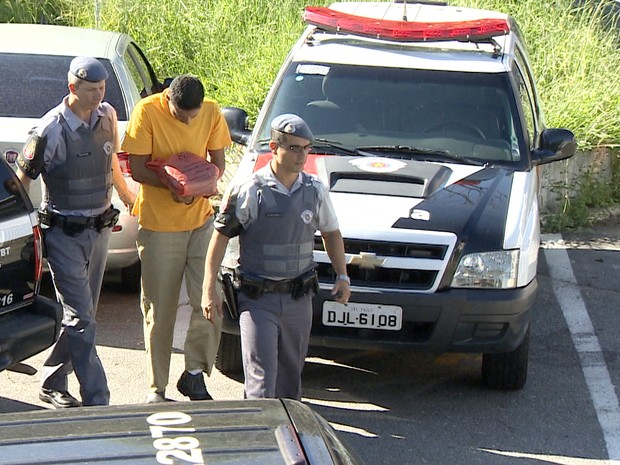 Policial militar chega escoltado até a sede da Delegacia de Investigações Gerais de Taubaté. (Foto: Reprodução/TV Vanguarda)