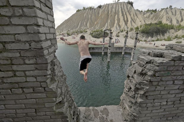 Homem salta para nadar nas ruínas da prisão de Murru, na Estônia (Foto: Ints Kalnins/Reuters)