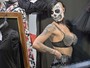 Participante exibe rosto com pintura de caveira em feira de tatuagens