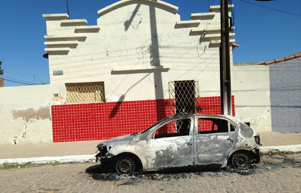 Carro da PM foi incendiado nesta madrugada em frente à delegacia da cidade (Foto: Reubem Avelino)