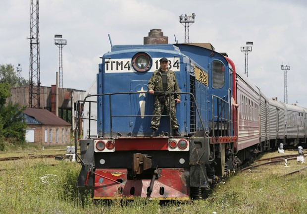 Soldado ucraniano é visto no trem que leva os corpos das vítimas do voo MH17 após a composição chegar à cidade de Kharkiv, controlada pelo governo, nesta terça-feira (22) (Foto: Gleb Garanich/Reuters)